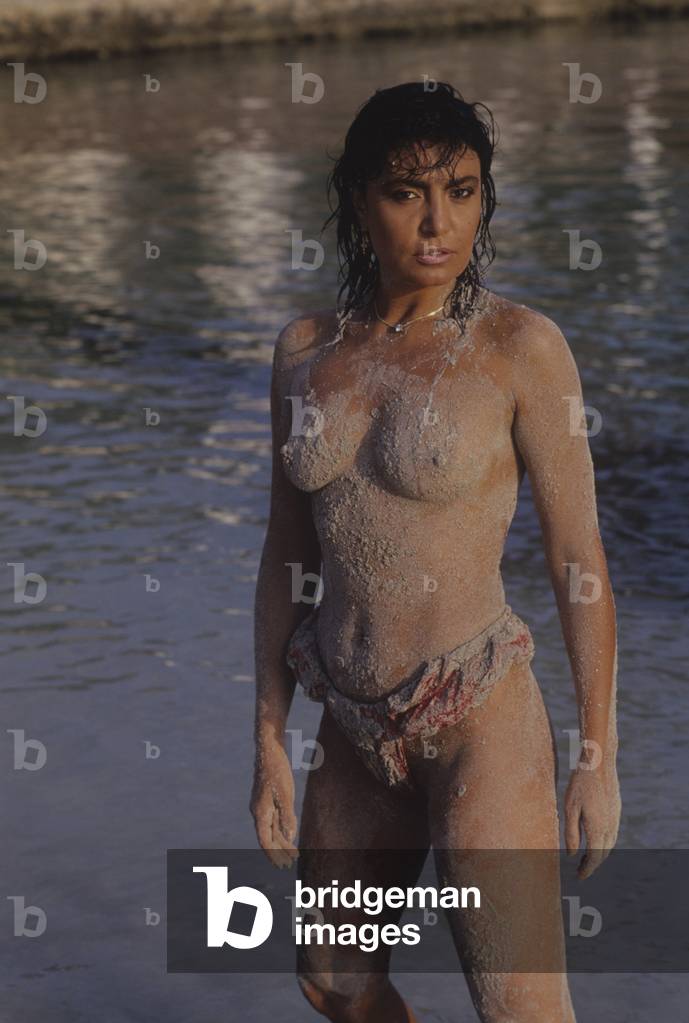 Loredana Berté covered in sand topless, Italy