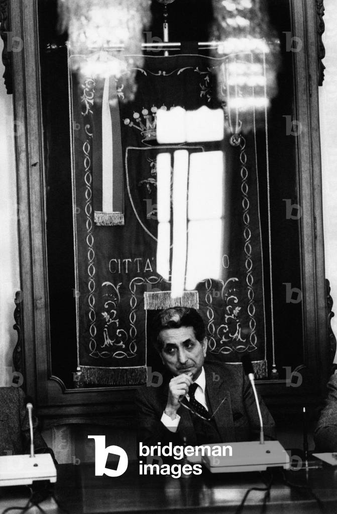 Diego Novelli sitting in front of the of Turin gonfalon