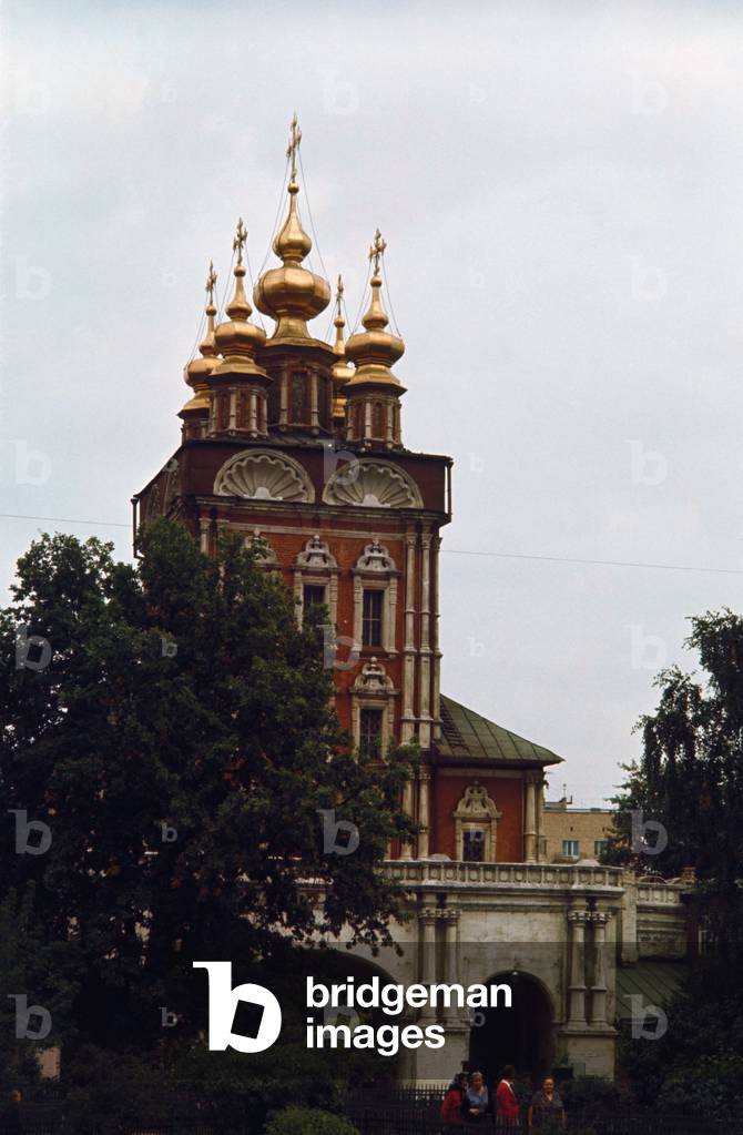 A high building with windows surrounded by five golden domes in Zagorsk
