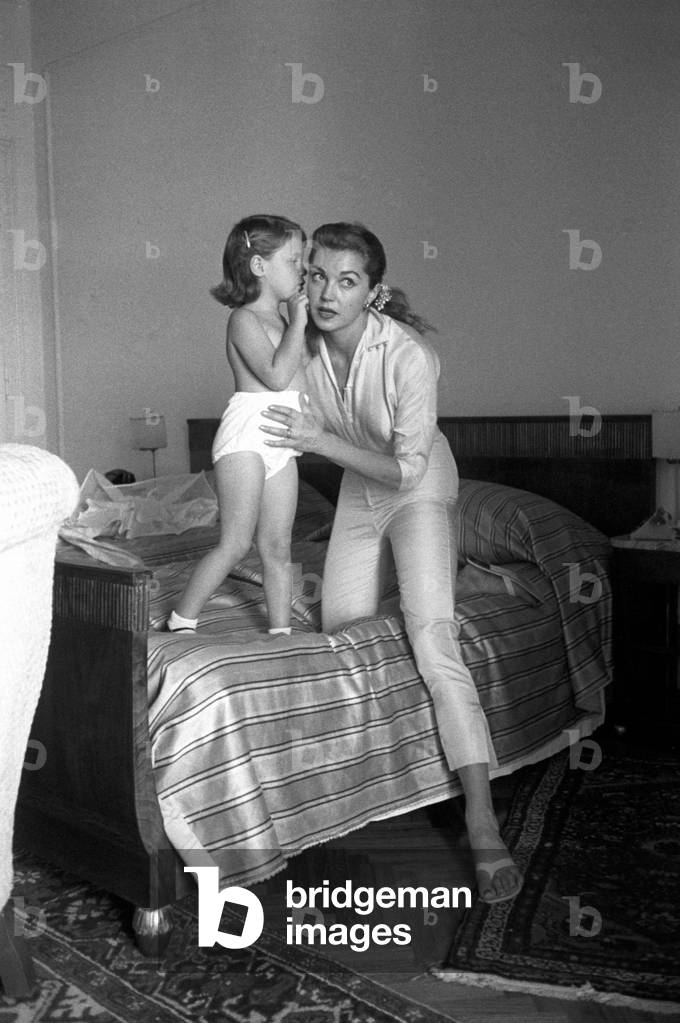 Esther Williams listens to her daughter who whispers at her ear