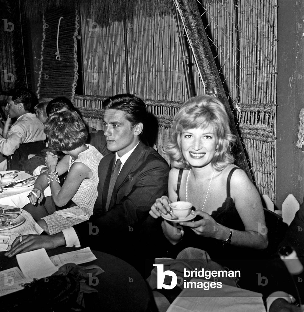 Monica Vitti and Alain Delon attending a dinner after an awarding ceremony, Rome, Italy, 1961 (b/w photo)