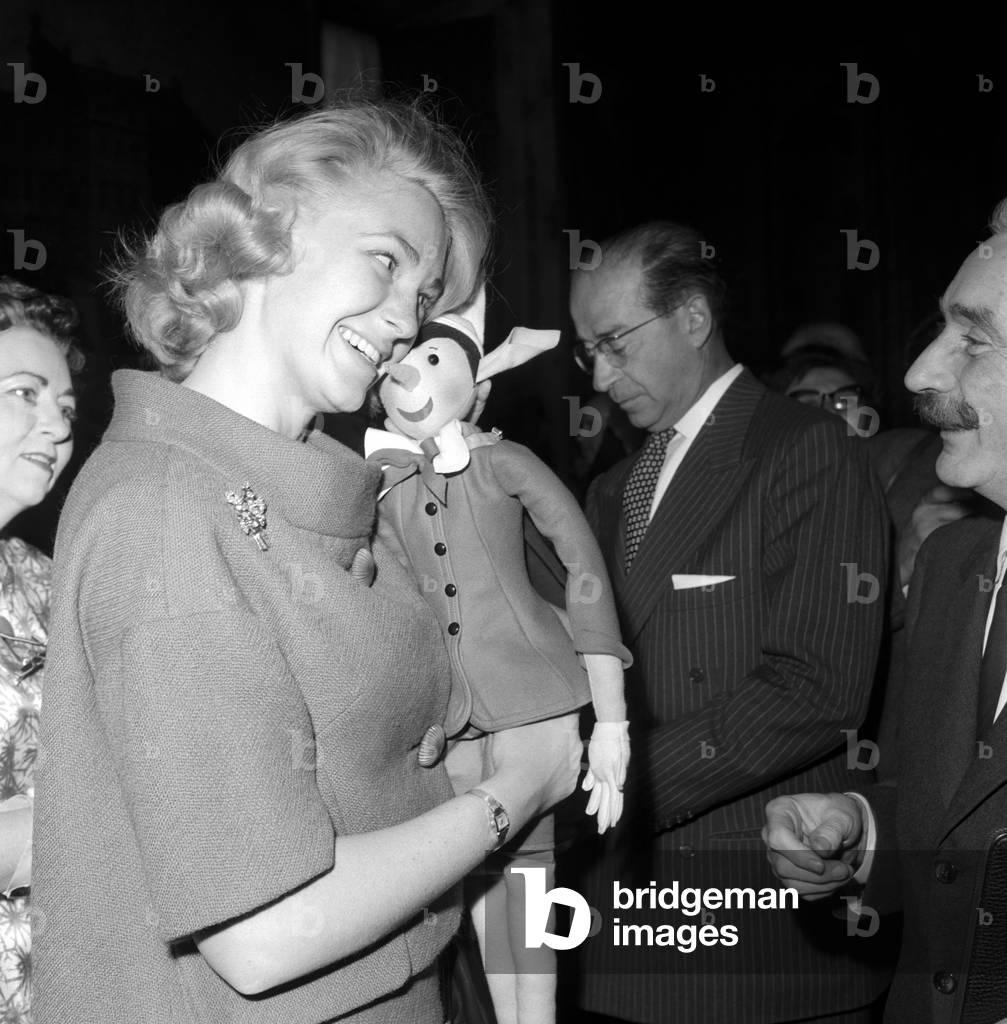 Joan Bennett Kennedy is receiving a Pinocchio puppet as a gift, 1961 (b/w photo)