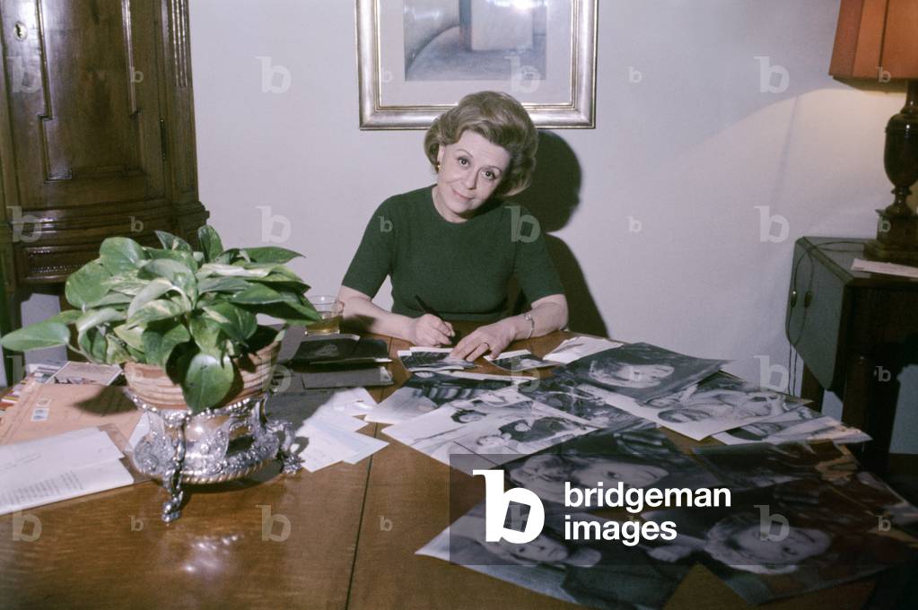Giulietta Masina signing autographs on her photos, Italy, 1976 (photo)