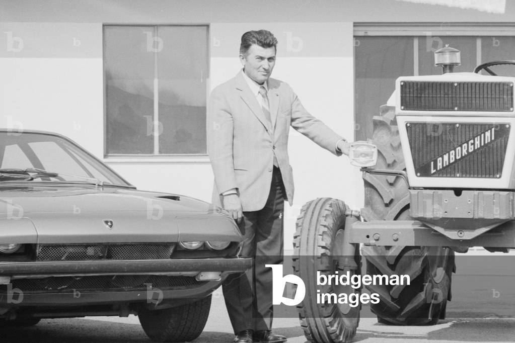 Ferruccio Lamborghini standing between a Lamborghini Jarama and a tractor, Italy, 1970 (b/w photo)