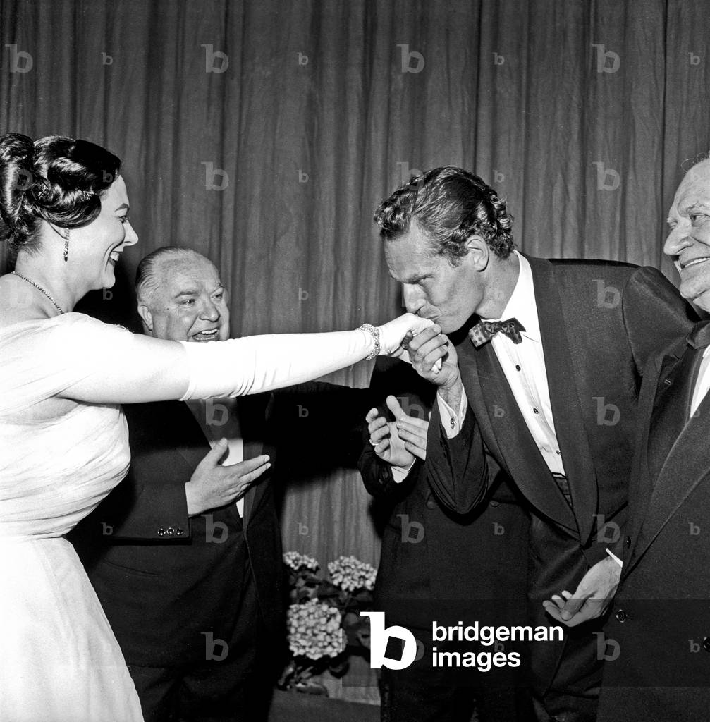 Charlton Heston kissing Renata Tebaldi's hand, Rome, Italy, 1958 (b/w photo)