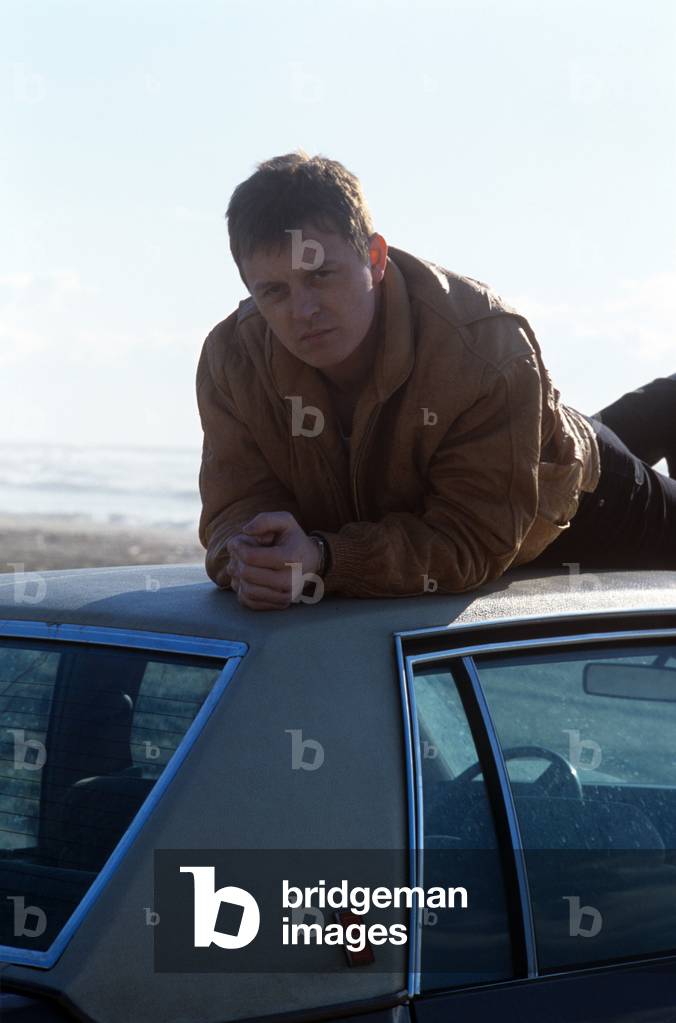 Zucchero lies down on the roof of a car