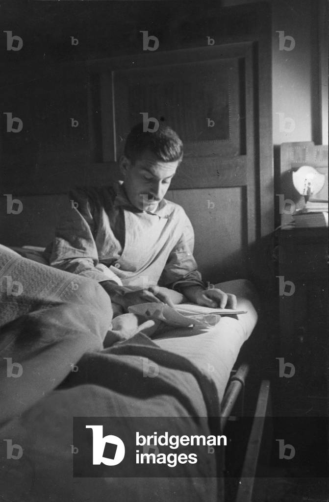 Elio Vittorini in pyjamas on his bed