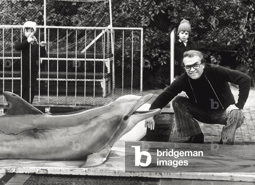 Giorgio Albertazzi poses next to a dolphin in Genoa