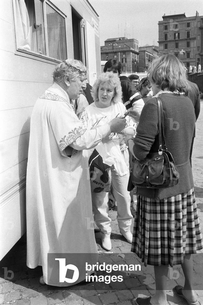 Peter Ustinov signing autographs, Italy, 1983 (b/w photo)