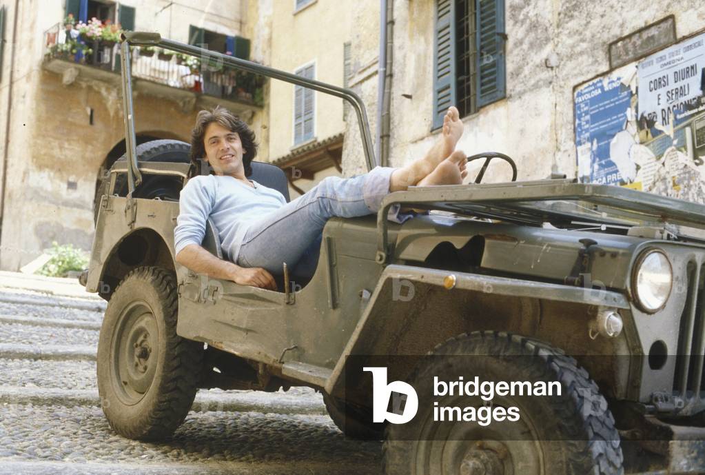 Riccardo Fogli posing lying on a jeep, Italy