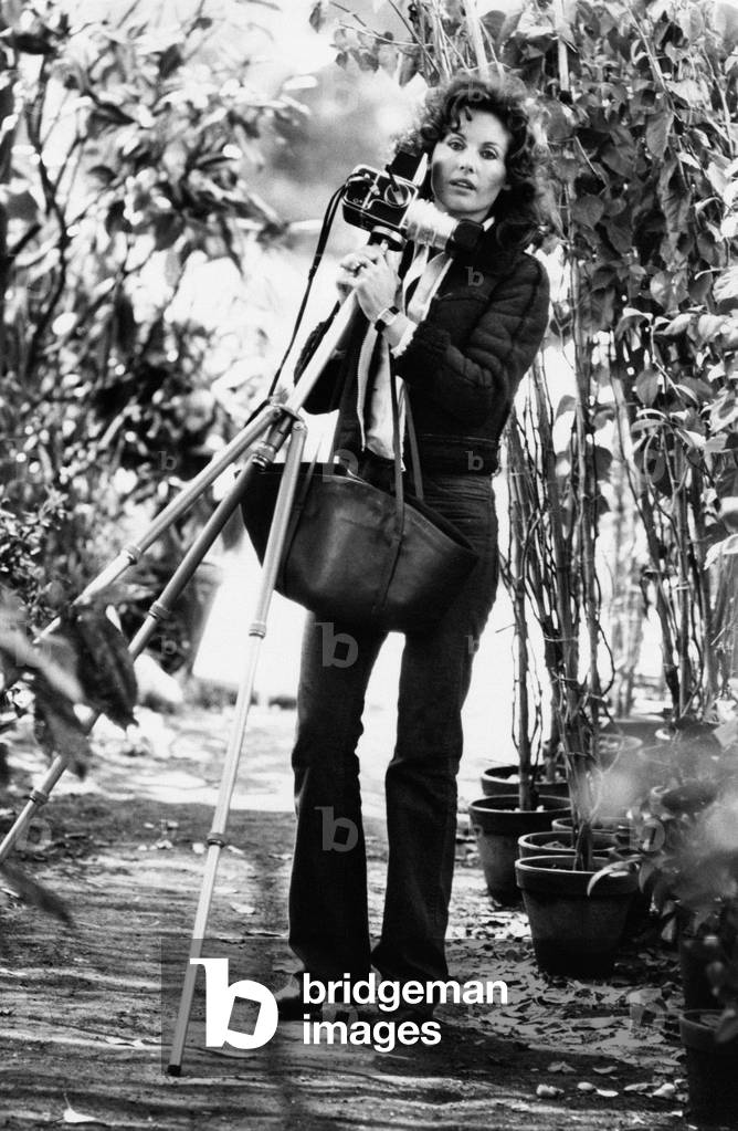 Gabriella Farinon picking up a camera with tripod