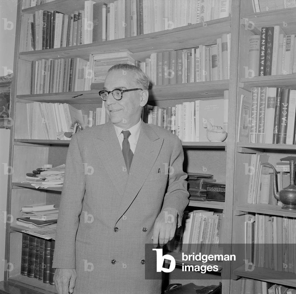 Ivo Andric leaning on a bookshelf, 1960 (b/w photo)