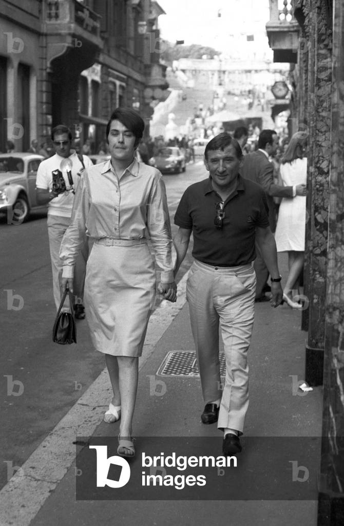 Renato Rascel and Huguette Cartier walking, Italy, 1966 (b/w photo)