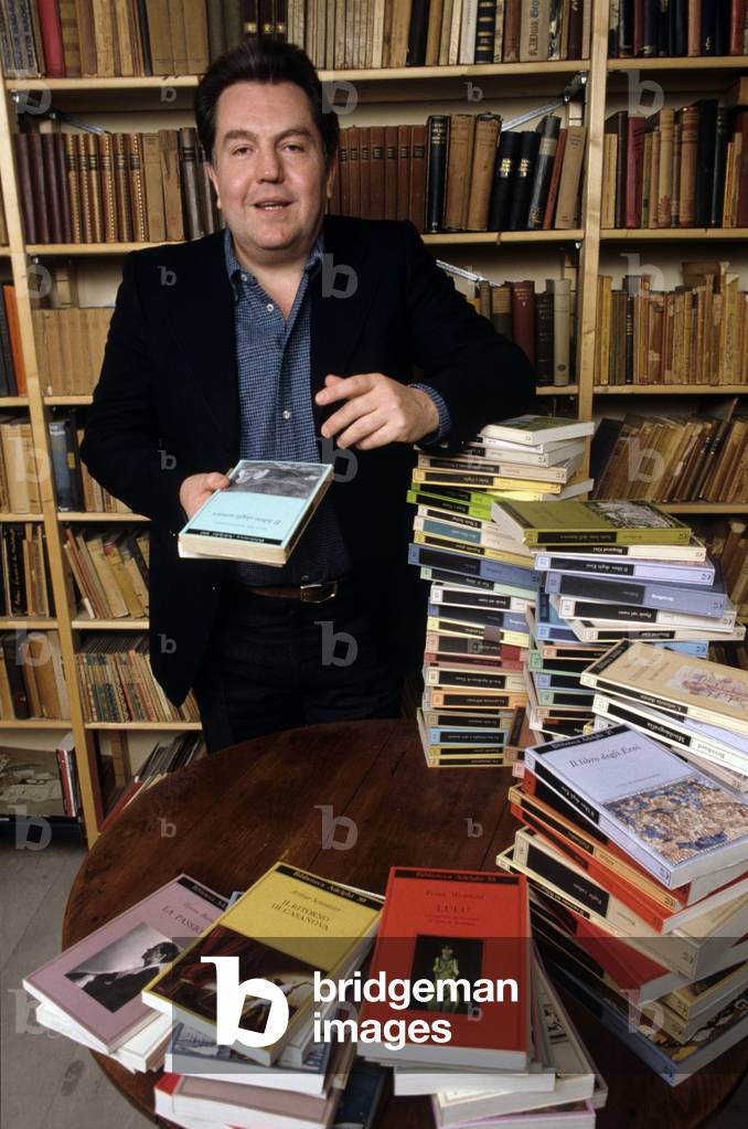 Giuseppe Pontiggia surrounded by books in a library