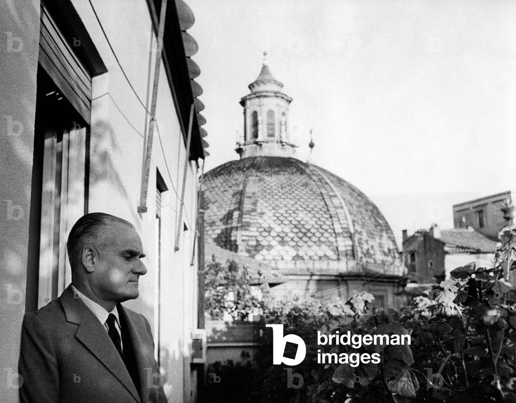 Writer Alberto Moravia on a terrace that overlooks a dome, Rome, Italy, 1961