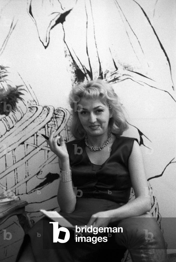 Anna Salvatore is smiling in front of one of her paintings