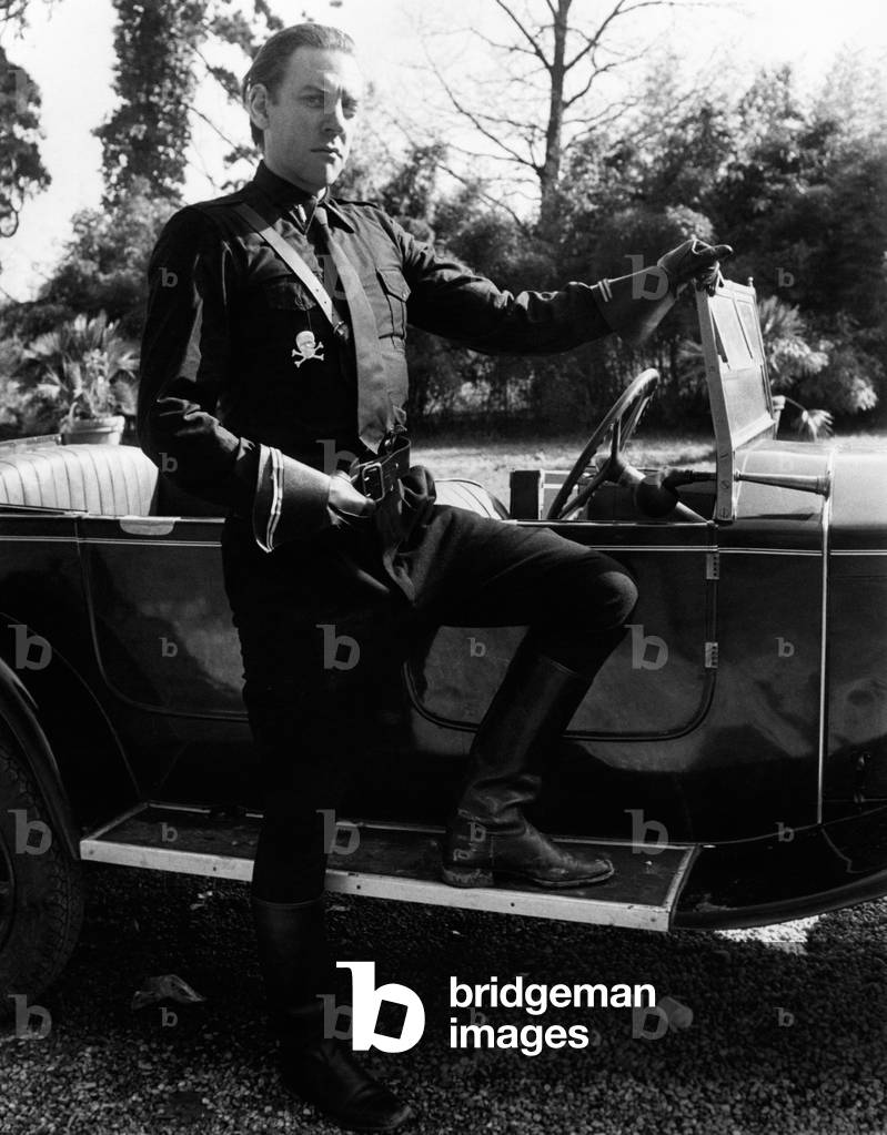 Donald Sutherland posing next to a Fiat Balilla