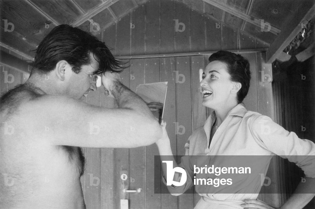 A man combing his hair into a wooden beach hut, Forte dei Marmi, Italy