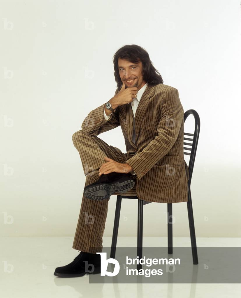 Claudio Cecchetto sitting on a chair