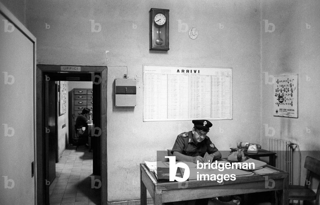 A policeman sitting in the office of the railroad police
