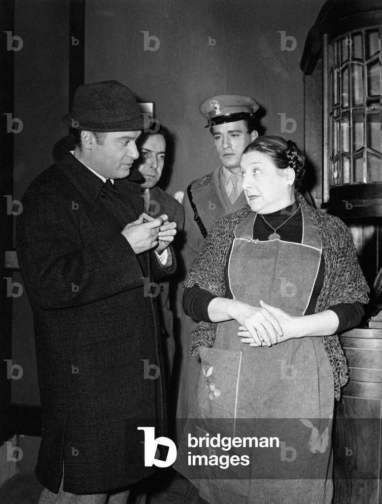 Paola Borboni is playing in a scene of a theatre comedy where she is wearing an apron