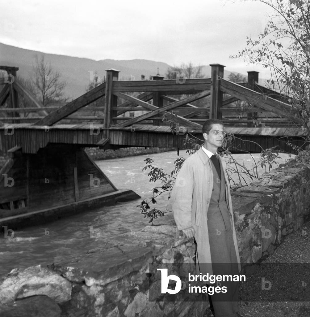 A citizen of Trentino-Alto Adige/Sudtirol leaning on a low wall at a riverbank, At that time the regional election in Trentino-Alto Adige/Sudtirol are held, Italy, November 1952 (b/w photo)