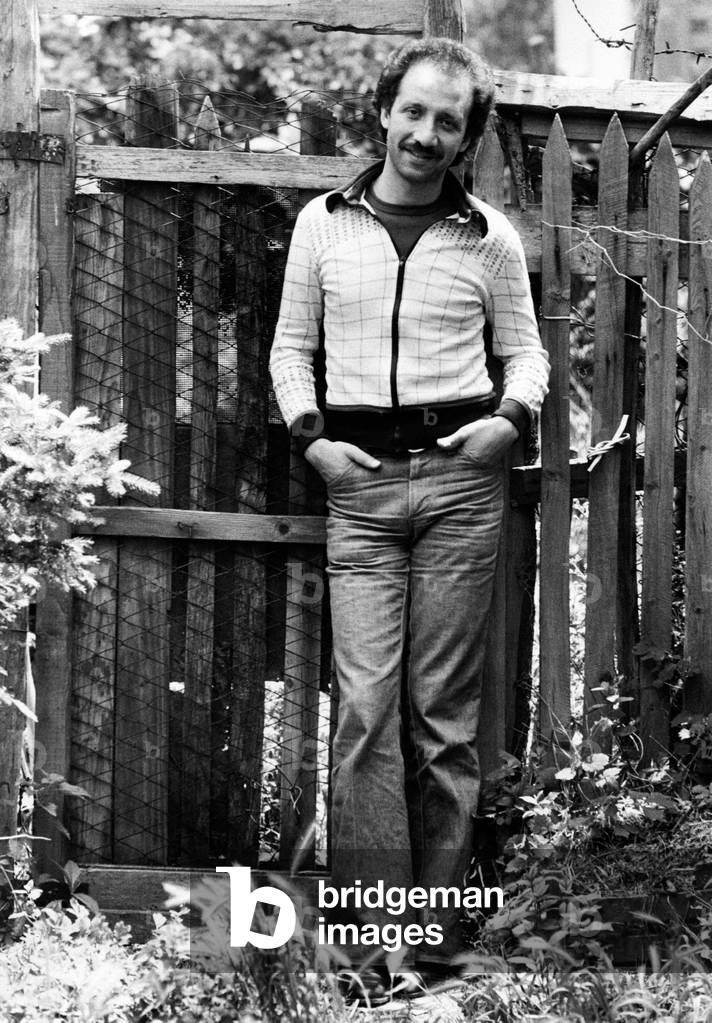 Umberto Balsamo smiling in front of a fence