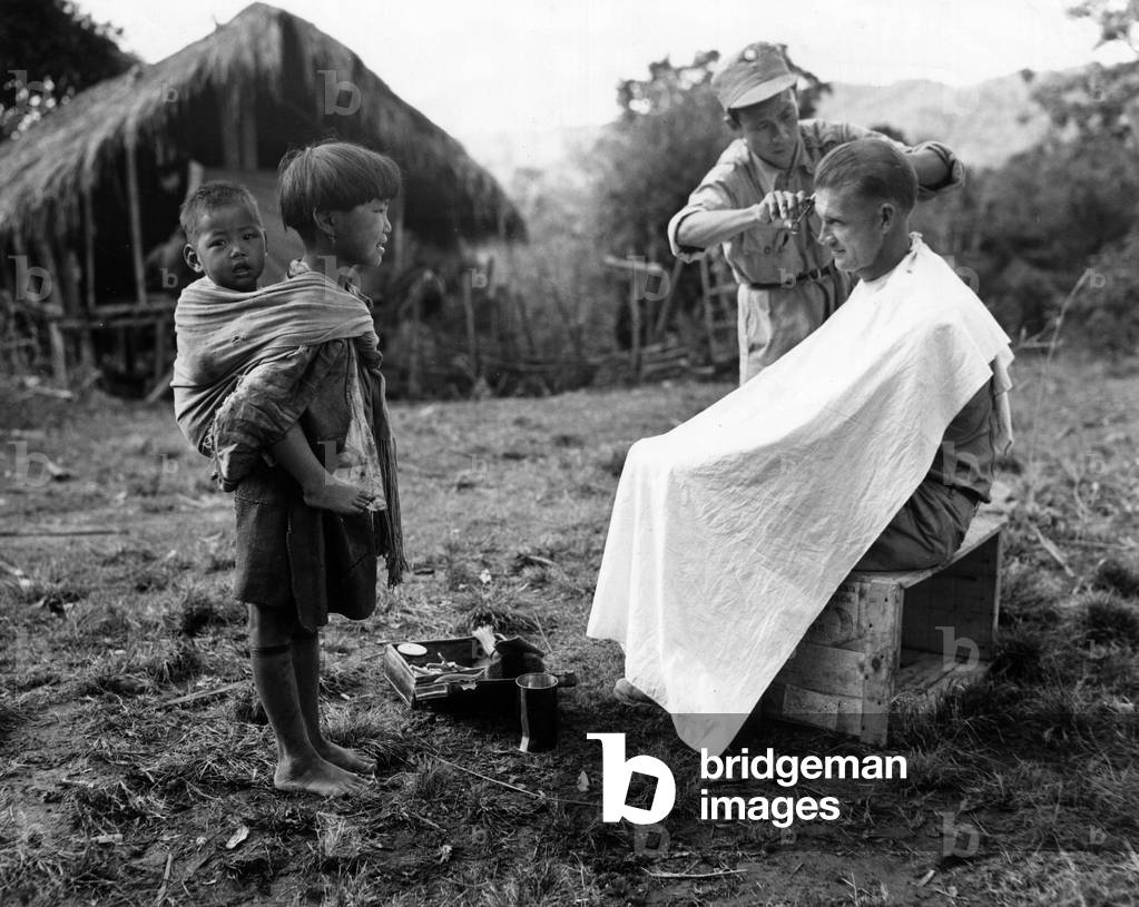 A Chinese soldier cutting the hair of a U.S. soldier