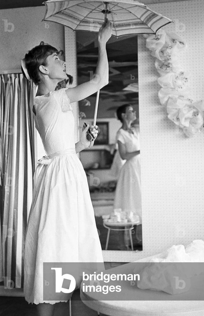 Audrey Hepburn opening an umbrella, Switzerland, Buergenstock, 1960 (b/w photo)