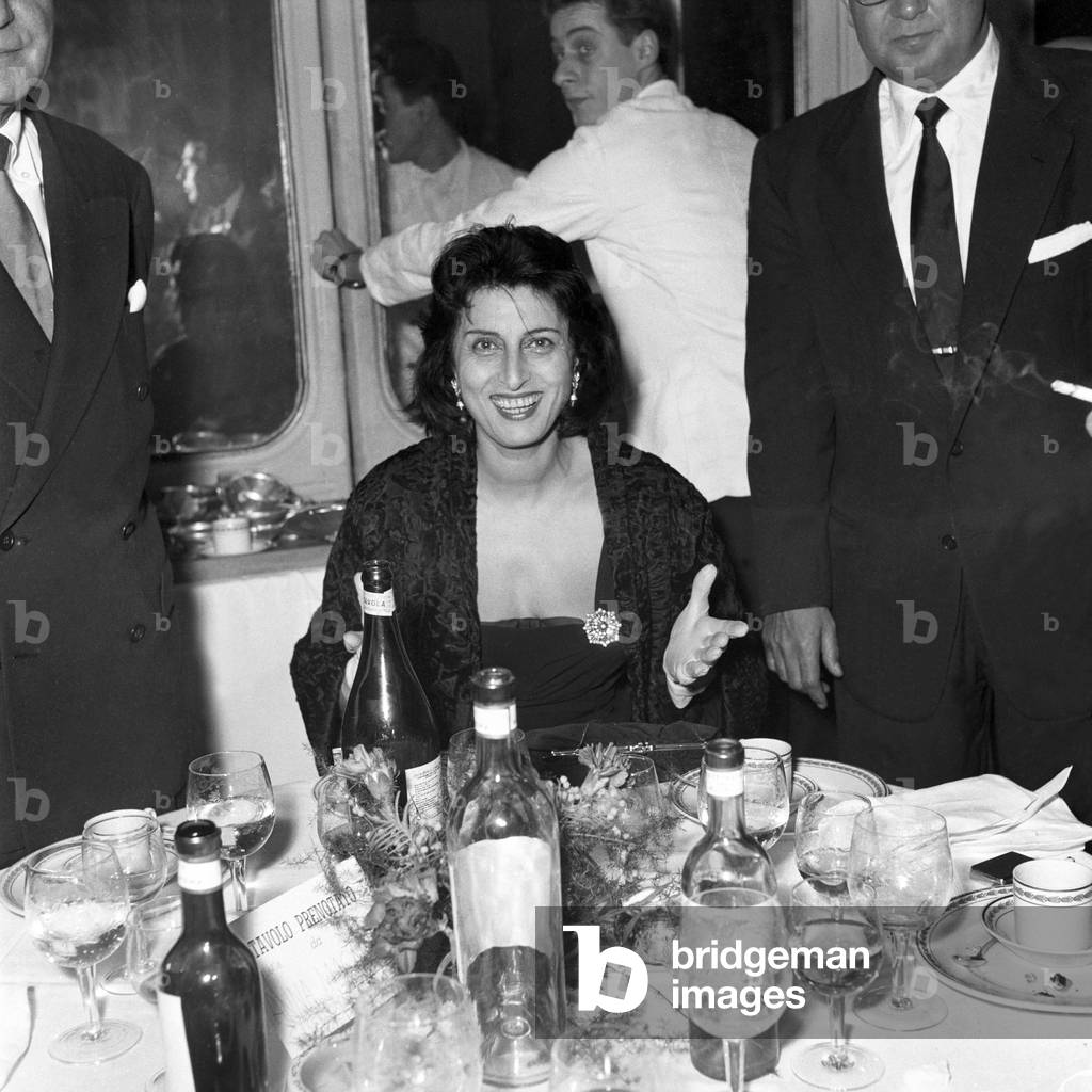 Anna Magnani sitting at the table, Italy, 1956 (b/w photo)