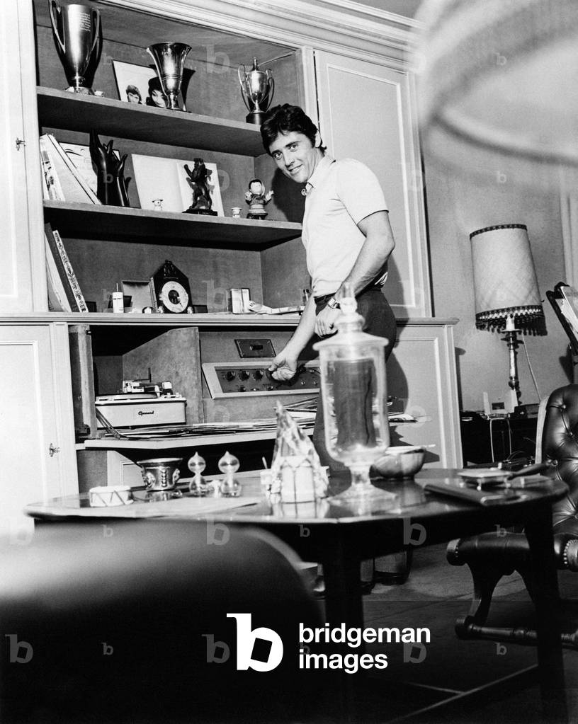 Sacha Distel adjusting the volume of a stereo system, Paris, France