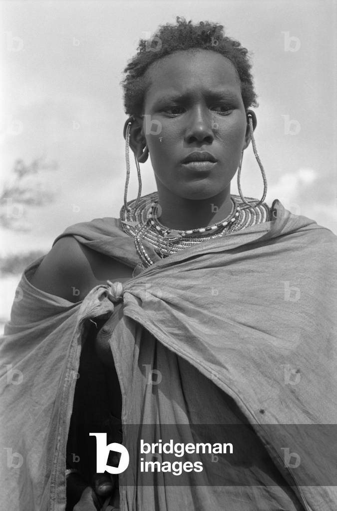 Young Kenyan woman posing nearby Nairobi, Kenya, April 1965 (b/w photo)