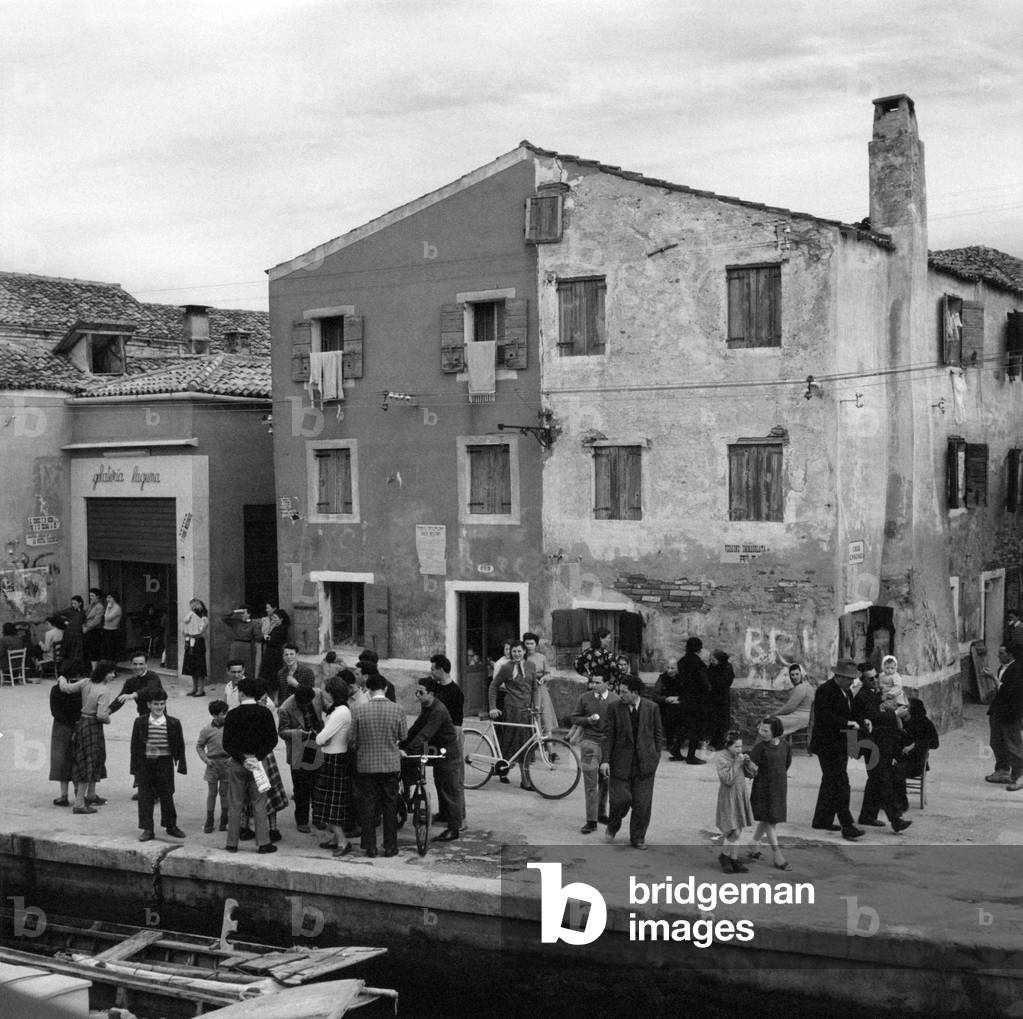 Some people meeting on the coastline of Malamocco, Venice, March 1954 (b/w photo)