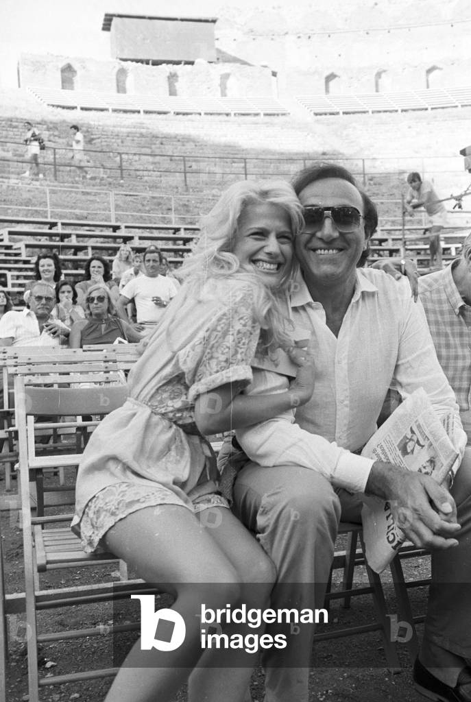 Pippo Baudo and Heather Parisi sitting in the Greek theatre of Taormina, Italy, 1984 (b/w photo)