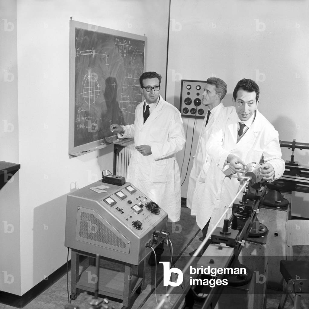 Emilio Gatti writing on a blackboard in his lab