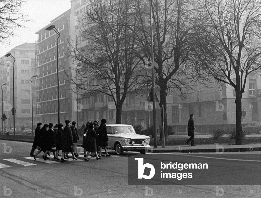 A car cuts pedestrian crossing passersby are passing through, Italy