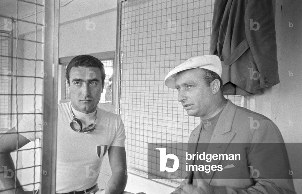 Italian car driver Eugenio Castellotti and Argentinian car driver Juan Manuel Fangio in the changing rooms of the Autodrome at Italian Grand Prix, Monza, Italy, 2nd September 1956 (b/w photo)