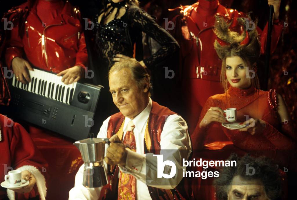 Renzo Arbore pours coffe to characters dressed like devils, Rome, Italy