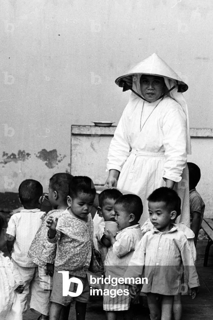 A Catholic nun and some young children at an orphanage of Saigon