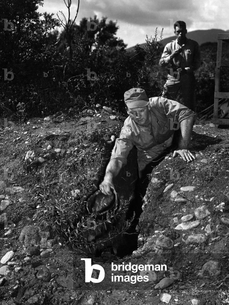 Two soldiers trying to remove water from a trench