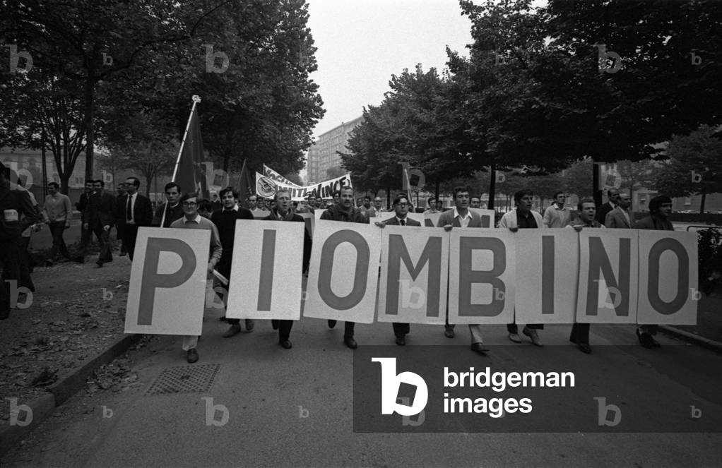 People marching behind a banner during a metalworkers' demonstration, Turin, 1969 (b/w photo)
