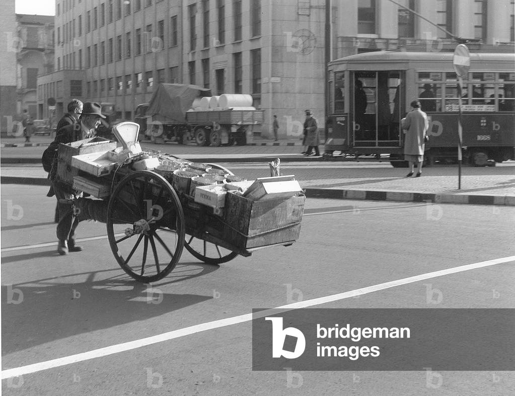 A fruitseller pushing his barrow, Italy, 1950 (b/w photo)