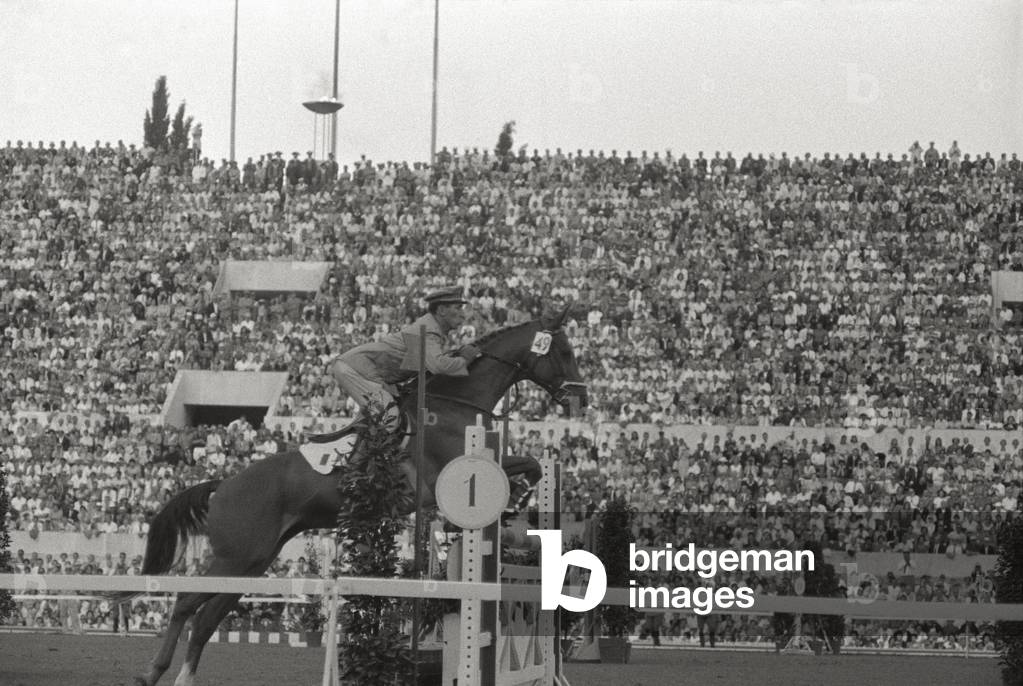 Raimondo d'Inzeo jumping a hurdle in the saddle of Posillipo, 1960 (b/w photo)