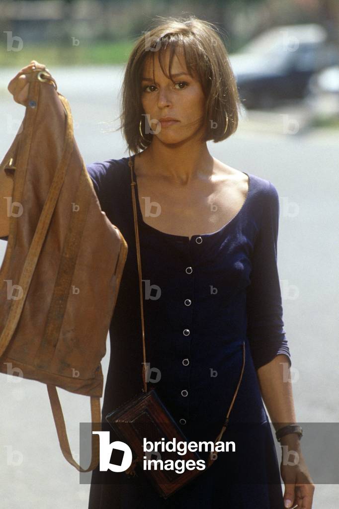 Christine Boisson on the street with a leather bag in his hand