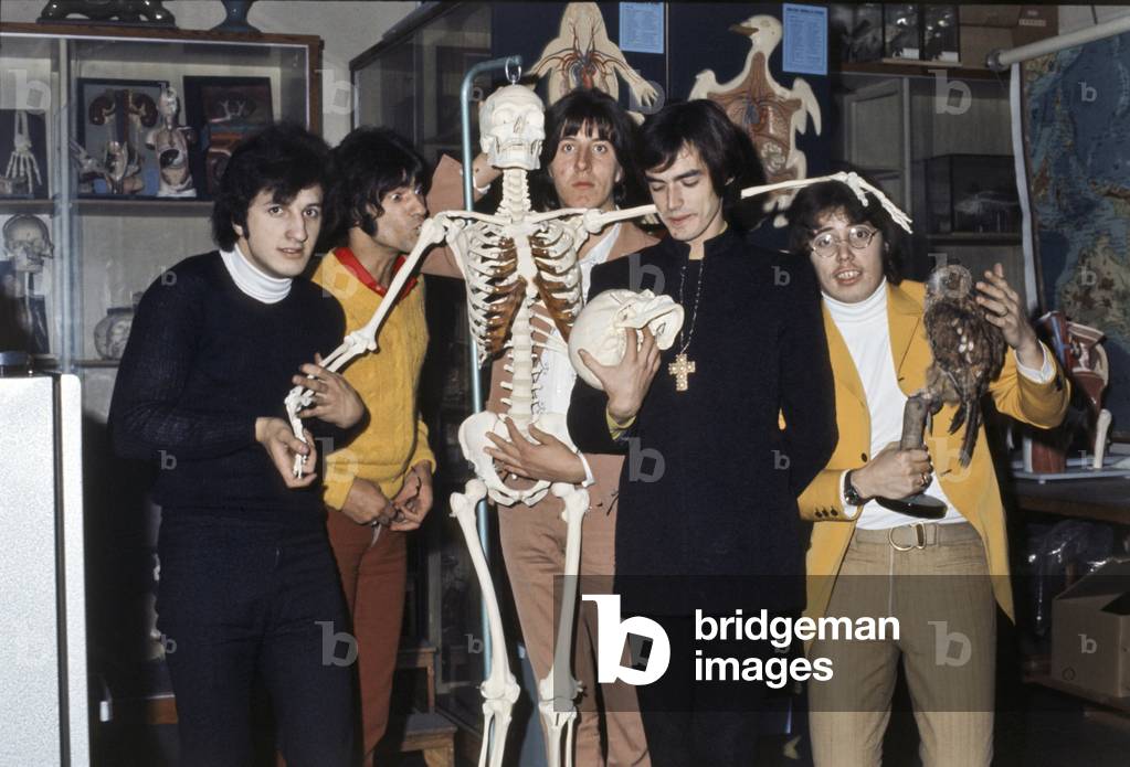 New Trolls joking with a skeleton model and other objects in a science classroom, Italy