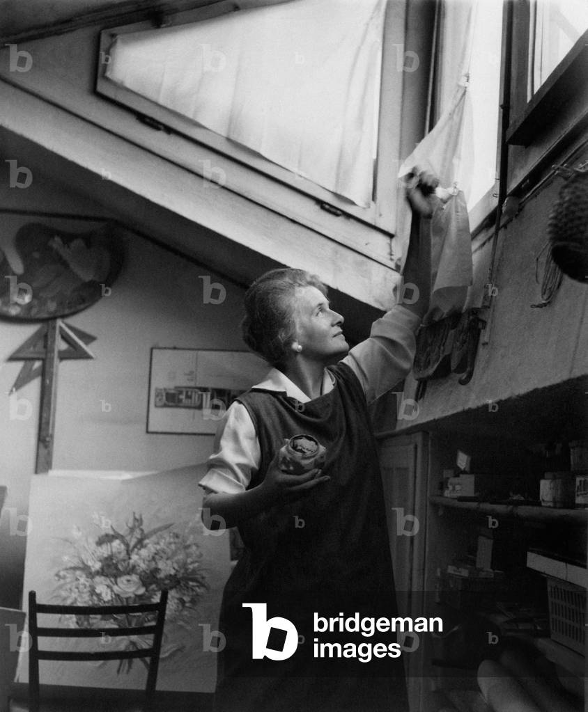 Felicita Frai pulls aside a little curtain in the window of his study