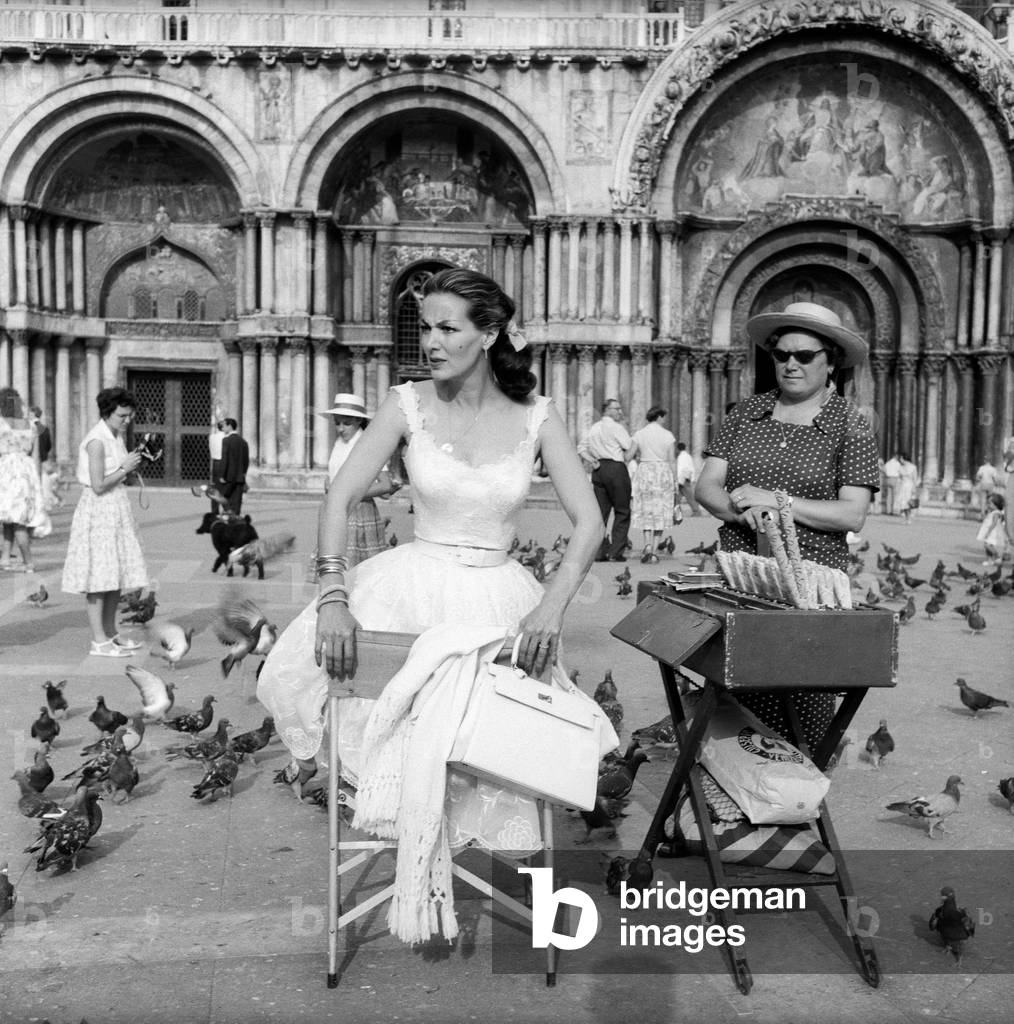 Maria Félix on Piazza San Marco beside a stall selling bird seed