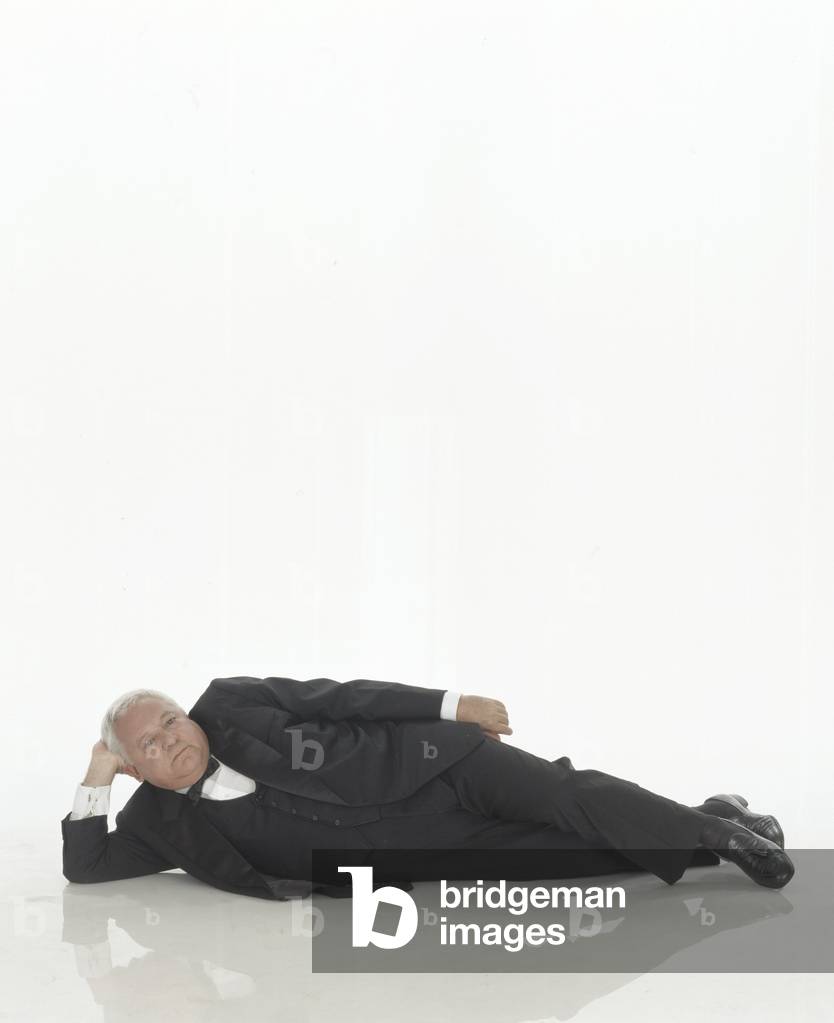 Paolo Villaggio lying on the floor on a photo set