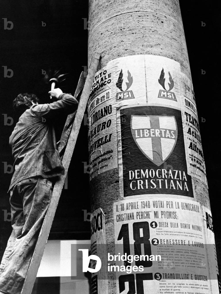Man sticking up election posters