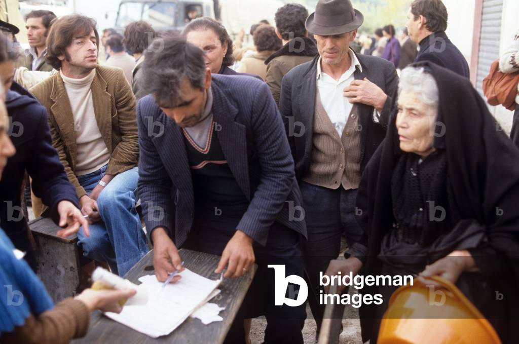 A man hit by the Irpinia earthquake reading a sheet of paper, Balvano, Italy, 1980